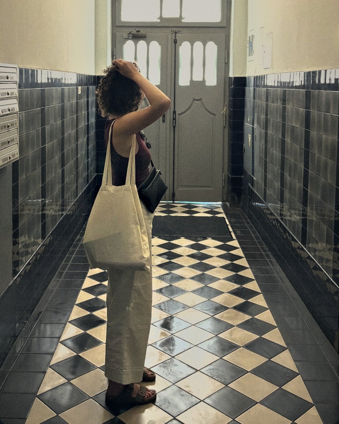 Martyna Paszek in a tiled hallway with a canvas bag