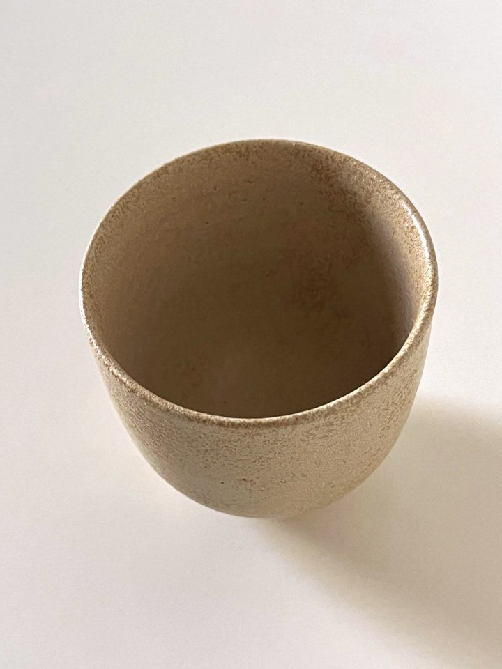 Handmade ceramic cup in a speckled warm sand glaze, second view