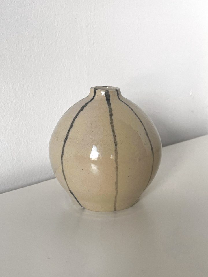 Round cream ceramic vase with a narrow neck and hand-painted dark stripes